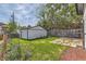 Fenced backyard with a detached garage, grass lawn, and stepping stone walkway at 1012 Fillmore St, Denver, CO 80206