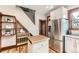Kitchen view features stainless steel refrigerator, butcher block island, and wooden shelves near staircase at 1012 Fillmore St, Denver, CO 80206