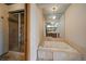 Bathroom featuring a soaking tub, glass enclosed shower, and a mirrored wall at 12007 W 54Th Dr, Arvada, CO 80002