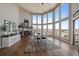 Bright dining area with a stone fireplace, large windows and hardwood floors create an inviting and elegant space at 12007 W 54Th Dr, Arvada, CO 80002