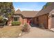 Inviting home entrance with a red door, brick facade, bay window and a well-maintained lawn at 12007 W 54Th Dr, Arvada, CO 80002