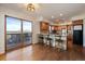 Open kitchen and dining area boasting wood cabinets, an island with bar stools, and a sliding door to the patio at 12007 W 54Th Dr, Arvada, CO 80002