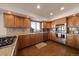 A kitchen features stainless steel appliances, wood cabinets, and hardwood floors at 12007 W 54Th Dr, Arvada, CO 80002