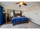 Spacious main bedroom featuring dark wood furniture, blue bedding and a ceiling fan at 12007 W 54Th Dr, Arvada, CO 80002