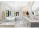 Bright bathroom with double sinks, soaking tub, glass enclosed shower, and modern fixtures at 2237 S Madison St, Denver, CO 80210