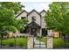 Charming two-story brick home with a manicured lawn and black iron fence and entrance gate at 2237 S Madison St, Denver, CO 80210