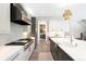 Bright kitchen with stainless appliances, white cabinetry, quartz counters, and a stylish backsplash at 2237 S Madison St, Denver, CO 80210