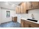 Well-organized laundry room with wooden cabinets, white subway tiles, and black sink at 2237 S Madison St, Denver, CO 80210