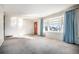 Bright living room featuring large bay windows with curtains and wall-to-wall carpeting at 6369 W 69Th Ave, Arvada, CO 80003