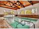 Indoor pool area with large windows and a wood beam ceiling at 6940 E Girard Ave # 307, Denver, CO 80224