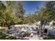 Outdoor pool area surrounded by trees and patio furniture at 6940 E Girard Ave # 307, Denver, CO 80224