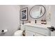 Stylish half bathroom with modern fixtures, a decorative mirror, and neutral tones at 420 Pleades Pl, Erie, CO 80516