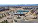 Aerial view of a modern community center with a pool, pond, and landscaped grounds, offering recreation and relaxation at 420 Pleades Pl, Erie, CO 80516