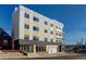 Modern three-story building with a mix of cream, gray, and black exterior, complemented by a clear blue sky and landscaping at 1208 N Quitman St # 405, Denver, CO 80204