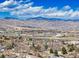 Distant aerial view of city and mountains under bright, cloudy sky at 126 Mc Intyre Circle, Golden, CO 80401