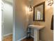 Charming powder room with pedestal sink, decorative mirror, and stylish lighting at 126 Mc Intyre Circle, Golden, CO 80401