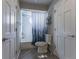 Bright bathroom with a shower-tub combo, gray tile flooring, and convenient shelving at 126 Mc Intyre Circle, Golden, CO 80401