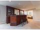 Basement wet bar with dark wood cabinetry, mirror backsplash, bar stools, and carpet at 126 Mc Intyre Circle, Golden, CO 80401