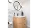 Stylish bathroom vanity features a modern round mirror and updated tile backsplash at 1169 Cook St, Denver, CO 80206