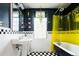 Stylish bathroom featuring a black clawfoot tub, checkered tile floor, and bright yellow shower curtain at 1169 Cook St, Denver, CO 80206