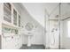 Well-lit bathroom featuring a shower with glass doors, sink, vanity and ample built-in storage at 1169 Cook St, Denver, CO 80206