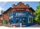 Exterior shot of the wine bar showing the blue facade, brick accents, and outdoor seating at 1169 Cook St, Denver, CO 80206