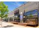 Exterior view of Blue Pan Pizza showing the entrance, outdoor seating, and gray brick facade at 1169 Cook St, Denver, CO 80206