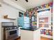 Kitchen featuring stainless steel appliances and colorful wallpaper at 1169 Cook St, Denver, CO 80206