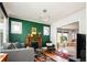 Living room with green accent wall, fireplace and wood floors at 1169 Cook St, Denver, CO 80206