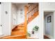 Classic wooden staircase featuring a landing with plants, light walls, and trim with natural light from a window at 1169 Cook St, Denver, CO 80206