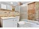 Bathroom featuring shower over tub and tan tiling at 948 S Tennyson St, Denver, CO 80219