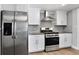 Modern kitchen featuring stainless steel appliances and white cabinetry, offering a clean and stylish design at 948 S Tennyson St, Denver, CO 80219