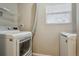 Bright laundry area with a modern white front-load washer and dryer at 2123 S Joplin Way, Aurora, CO 80013