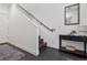 A tiled entryway with a staircase featuring a black handrail and console table with decor at 3036 Wilson Ct # 5, Denver, CO 80205