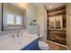 Stylish powder room featuring rustic wood accent wall, modern sink, and decorative mirror at 22025 Oehlmann Park Rd, Conifer, CO 80433