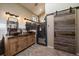 Modern bathroom with dual sinks, a tiled walk-in shower, and a rustic wood sliding barn door at 22025 Oehlmann Park Rd, Conifer, CO 80433