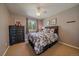 Cozy bedroom with a floral-patterned comforter, black dresser, and window with green scenery at 22025 Oehlmann Park Rd, Conifer, CO 80433