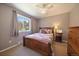Neutral bedroom with a wooden bed, plaid comforter, and large window providing natural light at 22025 Oehlmann Park Rd, Conifer, CO 80433