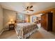Cozy bedroom with a decorative bed, ceiling fan and fireplace in an adjacent sitting area at 22025 Oehlmann Park Rd, Conifer, CO 80433
