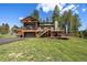 Beautiful home featuring a spacious deck, two-car garage, and perfectly manicured lawn in a tranquil, wooded setting at 22025 Oehlmann Park Rd, Conifer, CO 80433