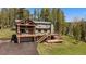 Charming home boasting a large deck perfect for outdoor gatherings and a two-car garage, surrounded by mature trees at 22025 Oehlmann Park Rd, Conifer, CO 80433