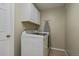 Bright laundry room features a white washer and dryer set and storage cabinets at 22025 Oehlmann Park Rd, Conifer, CO 80433