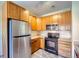 Kitchen with wood cabinets, stainless steel appliances, and tiled floor at 8200 E 8Th Ave # 2102, Denver, CO 80230