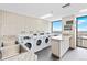 Well-equipped laundry room with multiple washers, sink, and convenient folding counter at 1625 Larimer St # 1806, Denver, CO 80202