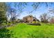 Lush backyard with mature trees, a pond, an outdoor patio, and a hot tub at 5020 W Quarles Dr, Littleton, CO 80128