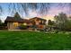 Spacious backyard with mature trees, a custom water feature, an outdoor patio, and plenty of room for entertaining at 5020 W Quarles Dr, Littleton, CO 80128