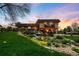 Stunning backyard featuring a custom water feature, patio, string lights, and mature landscaping at 5020 W Quarles Dr, Littleton, CO 80128