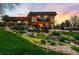 Beautifully landscaped backyard featuring a waterfall, lush greenery, and a cozy outdoor seating area at 5020 W Quarles Dr, Littleton, CO 80128