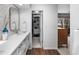 Bathroom vanity with white cabinets, closet and views to the bedroom and deck at 5020 W Quarles Dr, Littleton, CO 80128