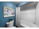 Bathroom with blue walls, a shower/tub with subway tile, and a modern, minimalist feel at 5020 W Quarles Dr, Littleton, CO 80128